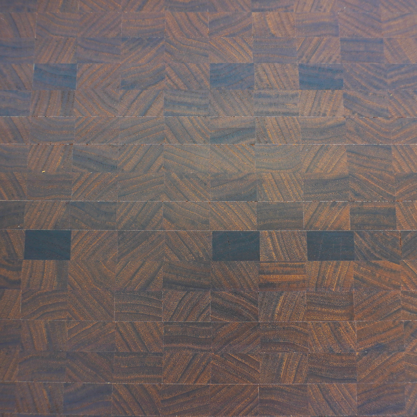 Macro close-up of the tight walnut wood fibers, demonstrating the precision sanding and finishing of Red Tail Boards.