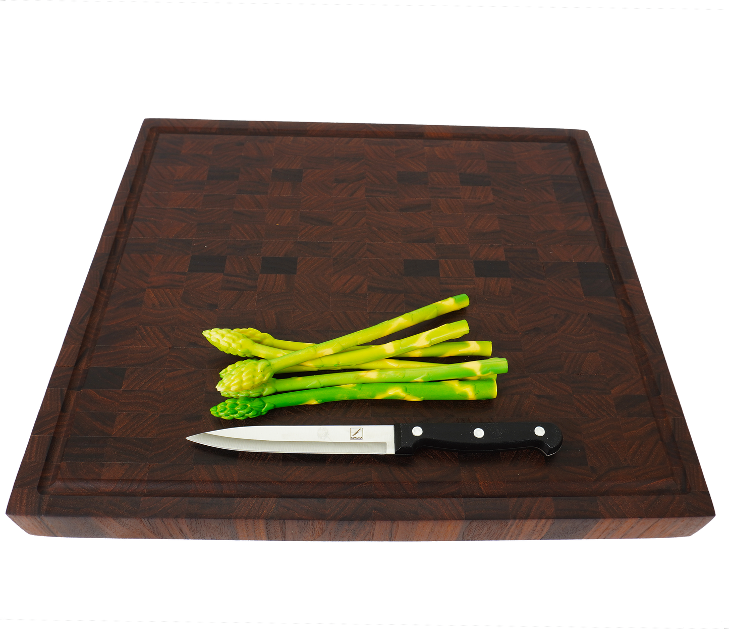 Perspective shot of the Sovereign board with asparagus, showcasing the durable, knife-friendly end grain surface.