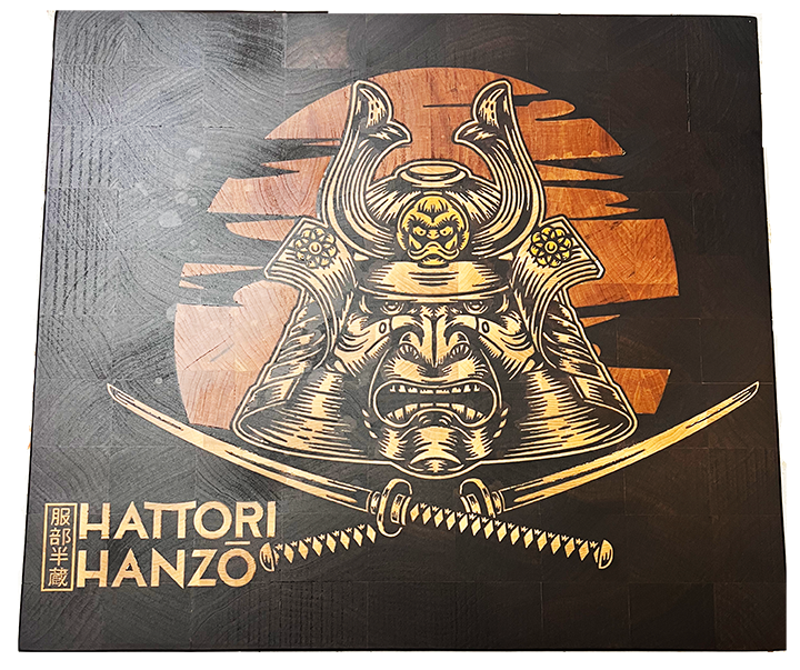 Custom walnut end-grain cutting board featuring an intricate Hattori Hanzo sword inlay crafted with precision from maple wood, yellowheart, and cherry woodwork.