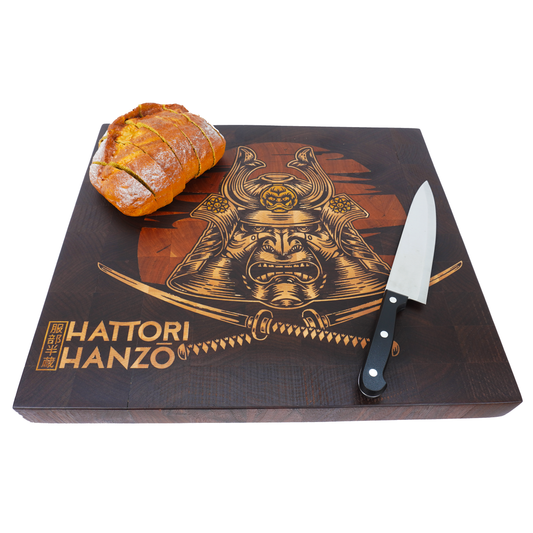 A 45-degree angle shot of the Hattori Hanzo walnut end grain board with a crusty loaf and bread knife, showcasing the handcrafted quality and durable end grain construction.