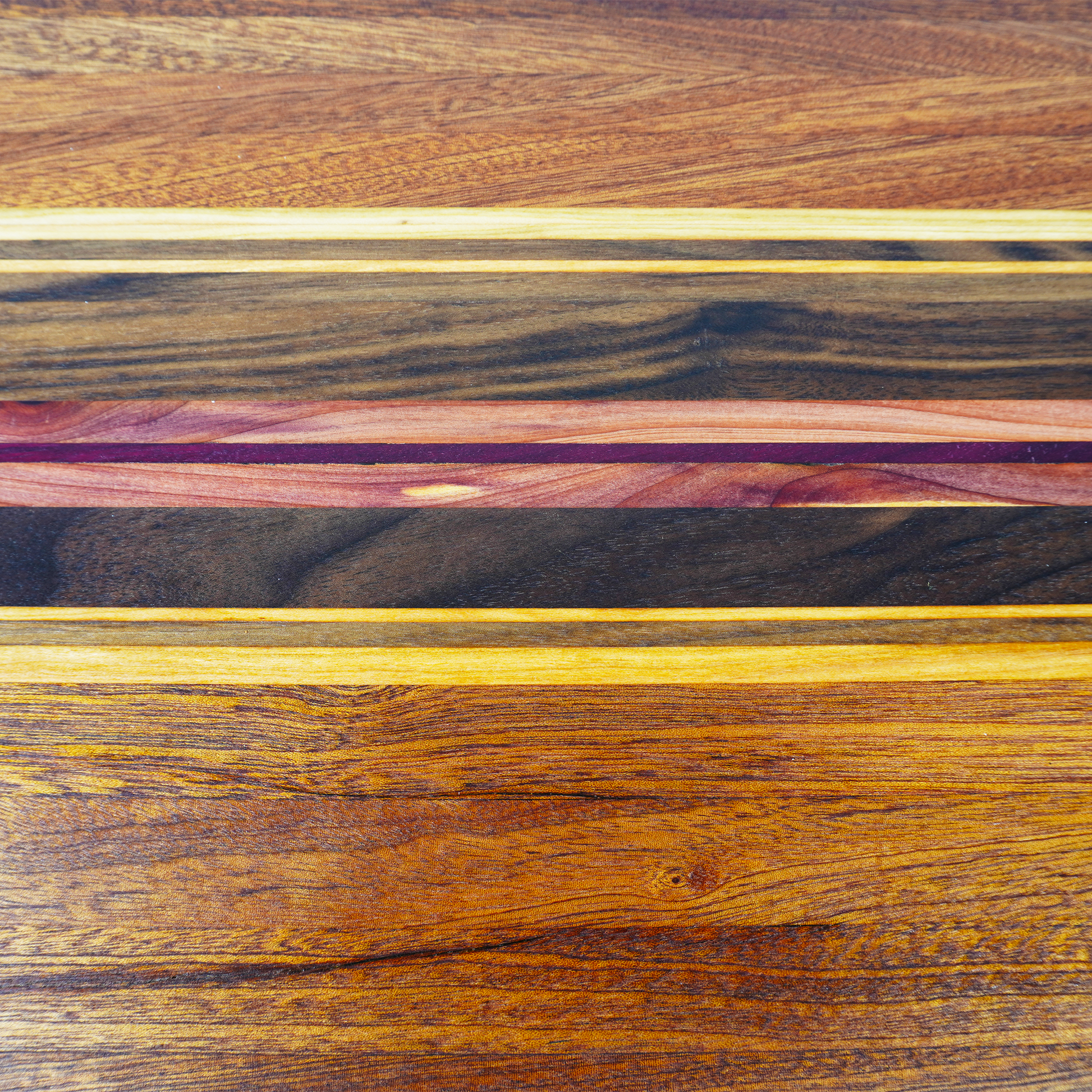Macro close-up of the Archive Collage 001, showcasing the tight grain and precision joinery of reclaimed wood planks, highlighting the natural iridescence of Sapele and Rosewood in this limited edition collection.