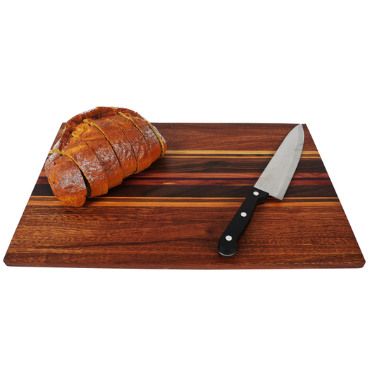 A 45-degree high-angle lifestyle shot of the Archive Collage 001, showcasing the rich texture of an old wood plank with a bread loaf and chef's knife, highlighting the board's durable face-grain construction.