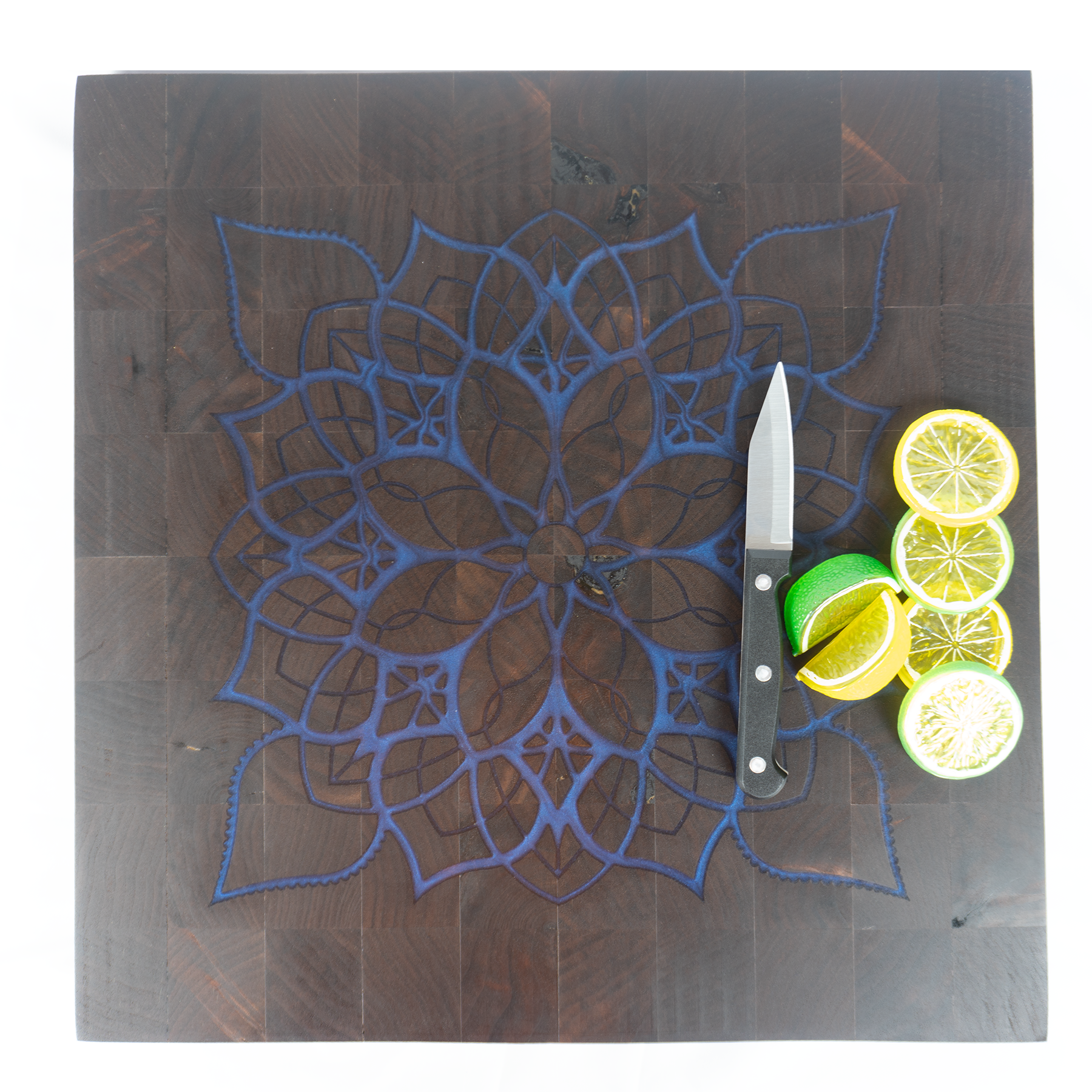 Walnut end grain blue epoxy mandala board with lemon limes and knife top view — Red Tail Boards