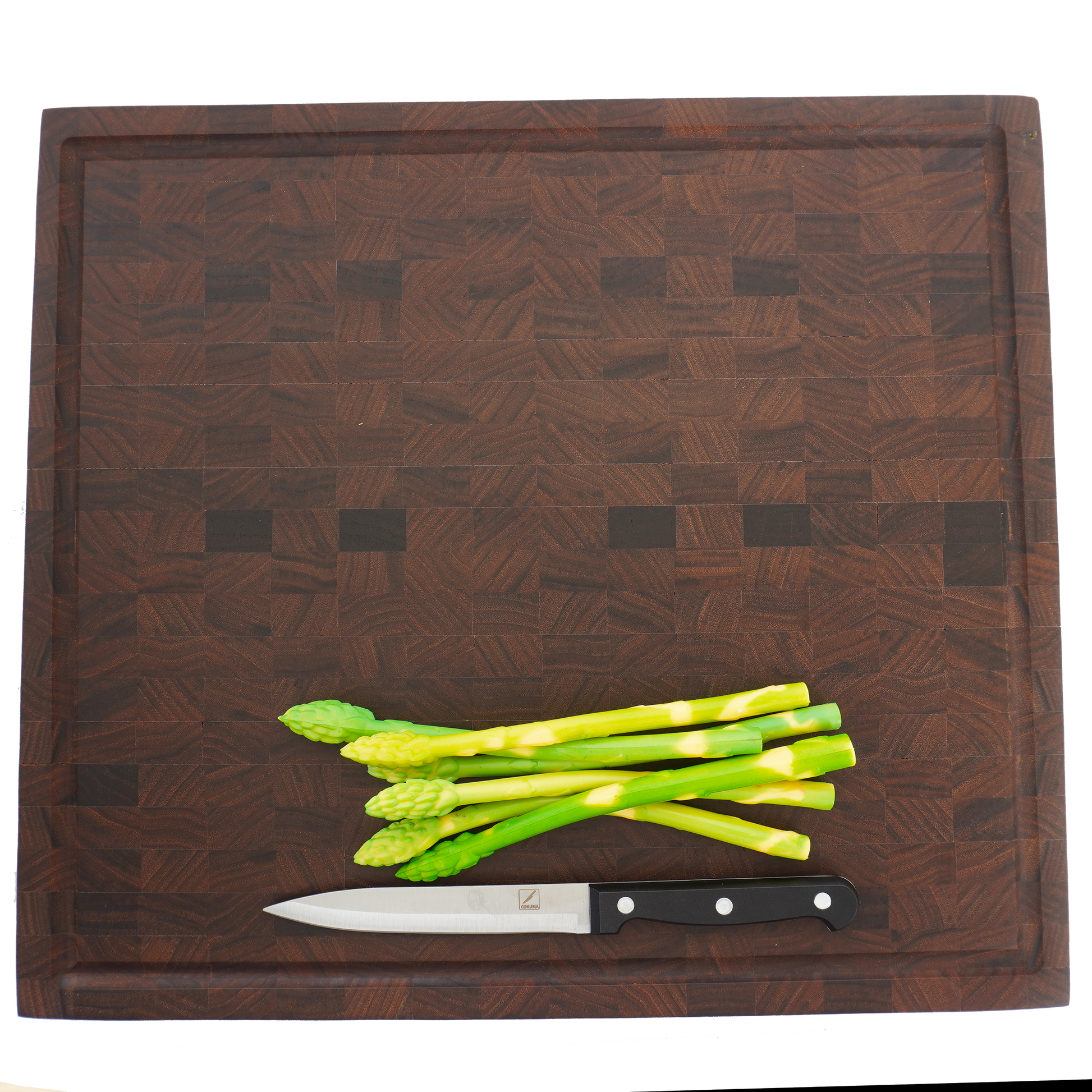 Level shot of asparagus on a walnut end grain board, highlighting its use as a professional chef's prep station.
